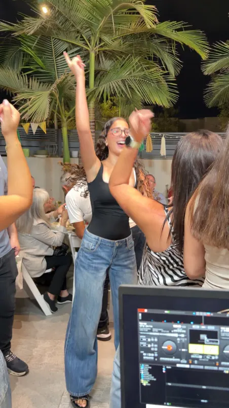 אורחת רוקדת ליד עמדת ה־DJ במסיבת יום ההולדת אורחת רוקדת ליד עמדת ה־DJ במסיבת יום ההולדת